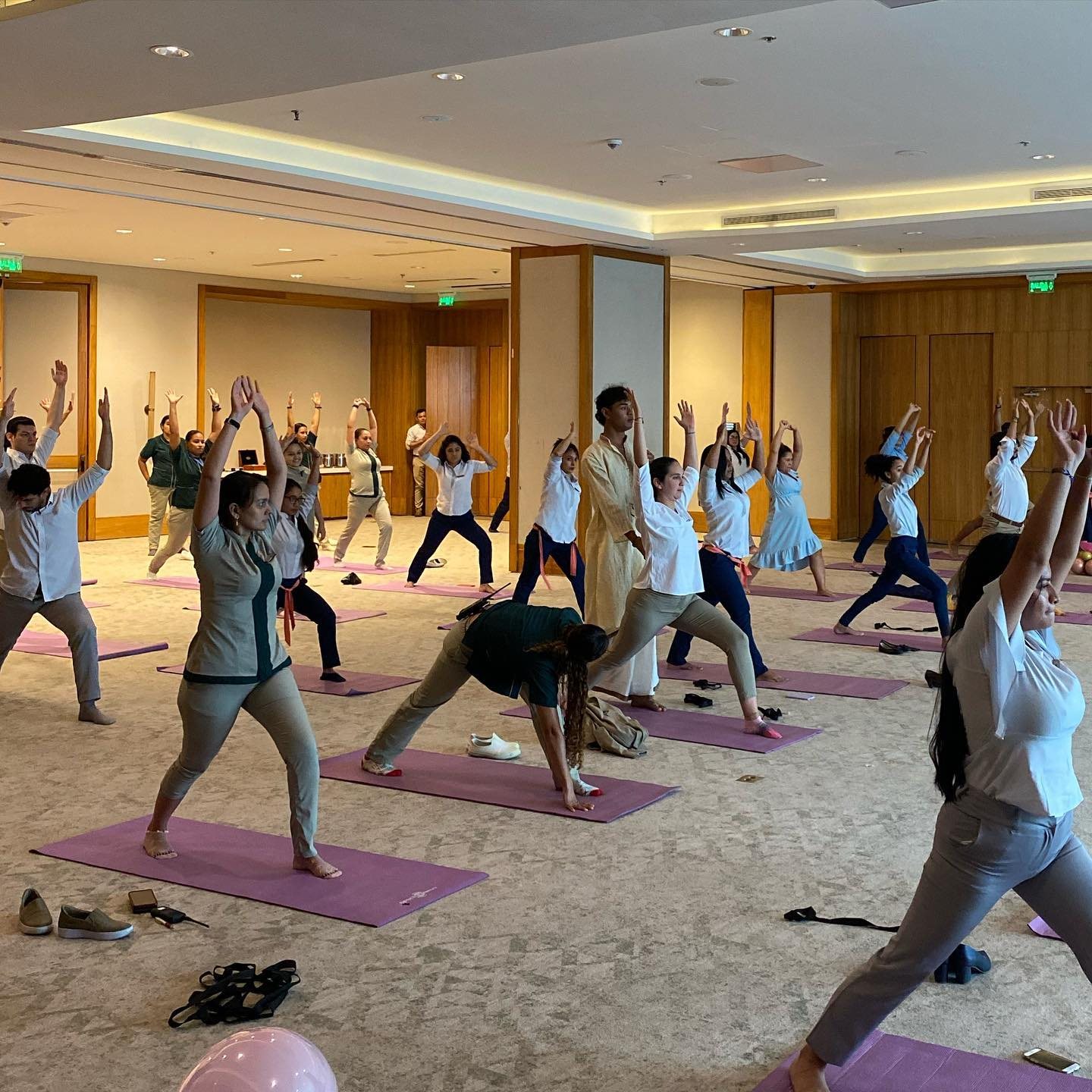 Grupo numeroso practicando yoga en conjunto durante un taller